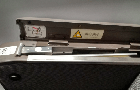 開蓋后可以看到一塊金屬板，這個(gè)就是藏起來的高鐵小桌板，向上將其拉出。